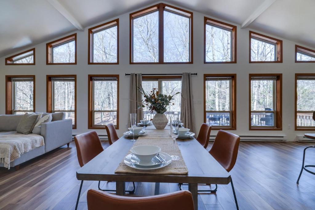 a dining room with a table and chairs and windows at Serene Escape At Big Bass Lake & Pool Access in Clifton