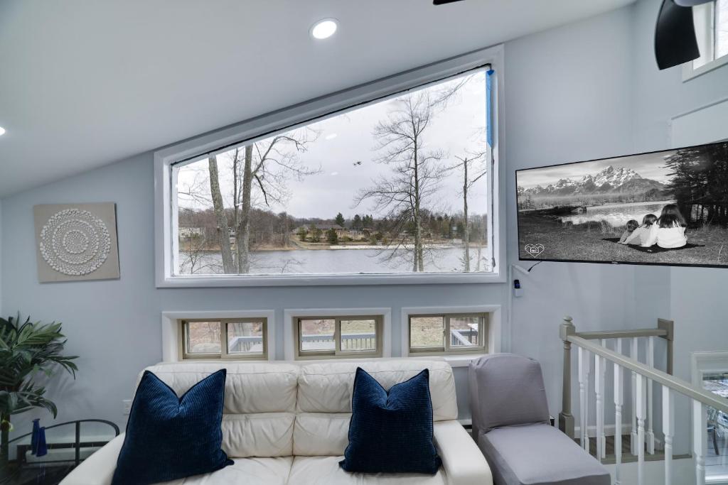 un soggiorno con un divano e una grande finestra di Lakeside Escape Hot Tub Private Dock a Tobyhanna