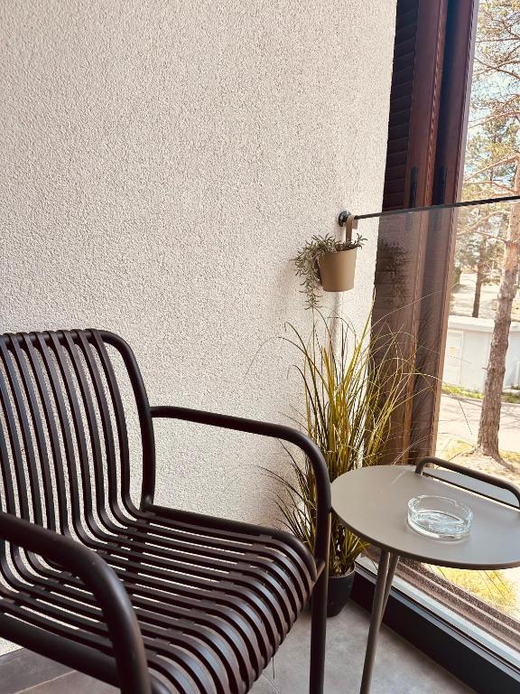 a black chair and a table and a window at Studio Apartman Nomad Divčibare in Divčibare