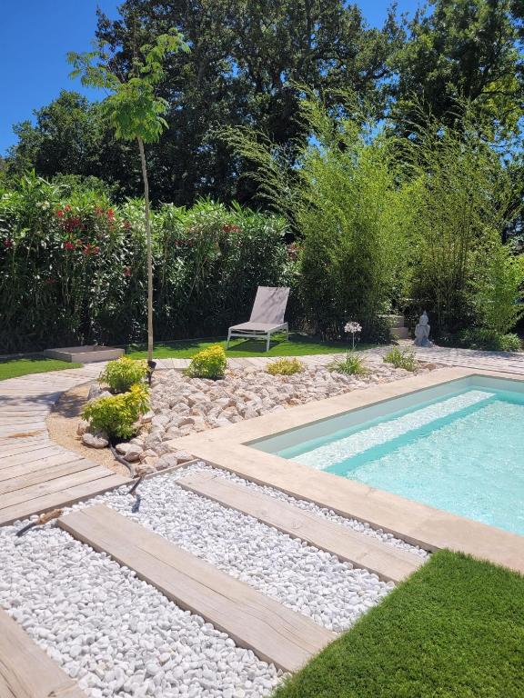 - une piscine dans un jardin avec une chaise à côté dans l'établissement Villa raffinée, piscine, jardin, proche Cassis et Marseille, à Aubagne