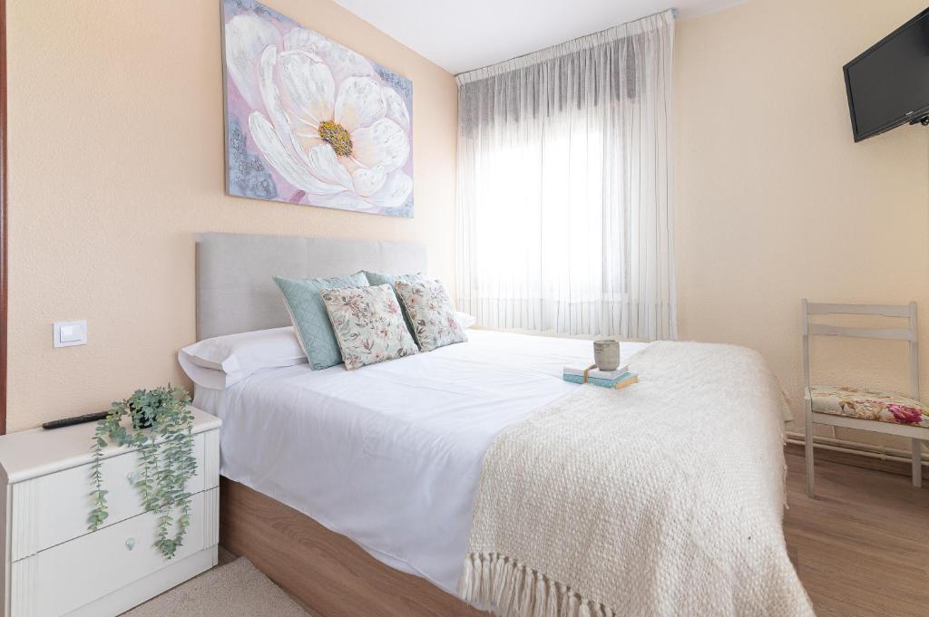 a bedroom with a bed and a tv and a window at Mi casita del norte a 150 m de la playa in Mogro