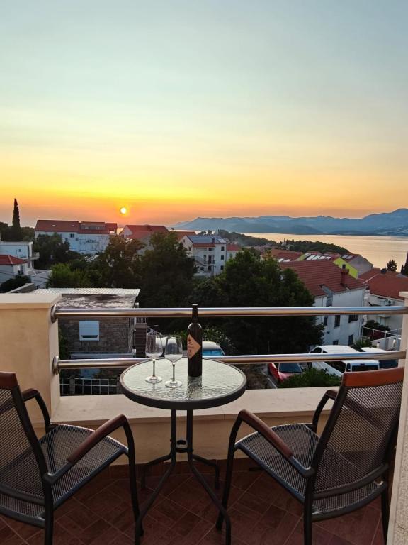 eine Flasche Wein auf einem Tisch auf einem Balkon in der Unterkunft Apartments Miljas in Cavtat