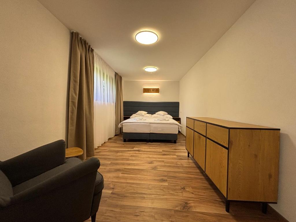 a bedroom with a bed and a chair and a couch at Chata Lipa in Bešeňová
