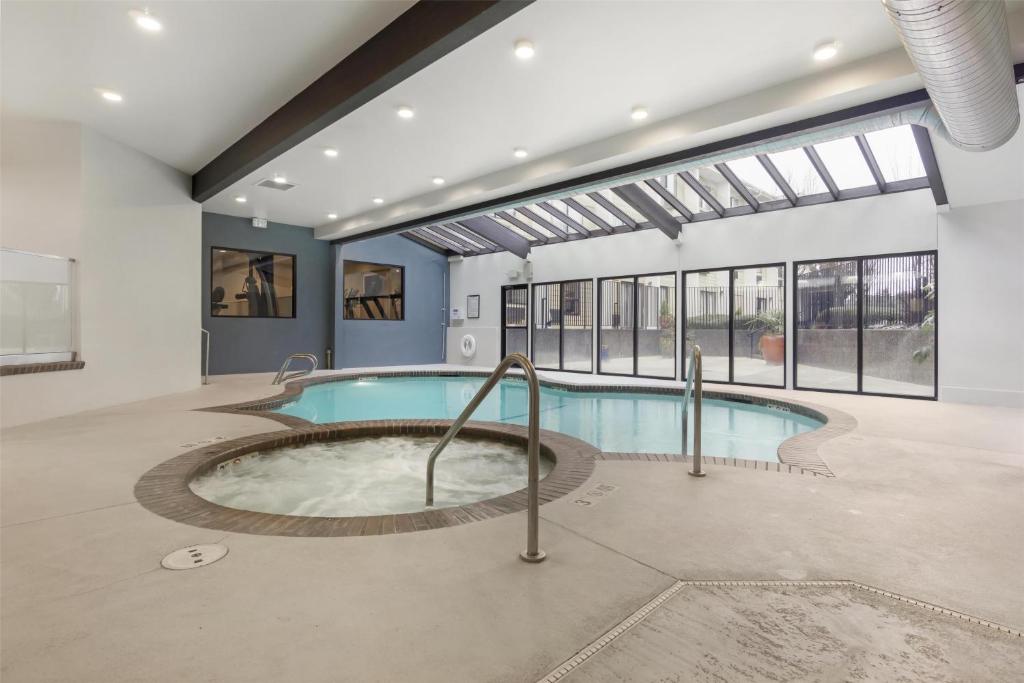 an indoor pool with a hot tub in a building at Best Western Seattle Airport Hotel in SeaTac