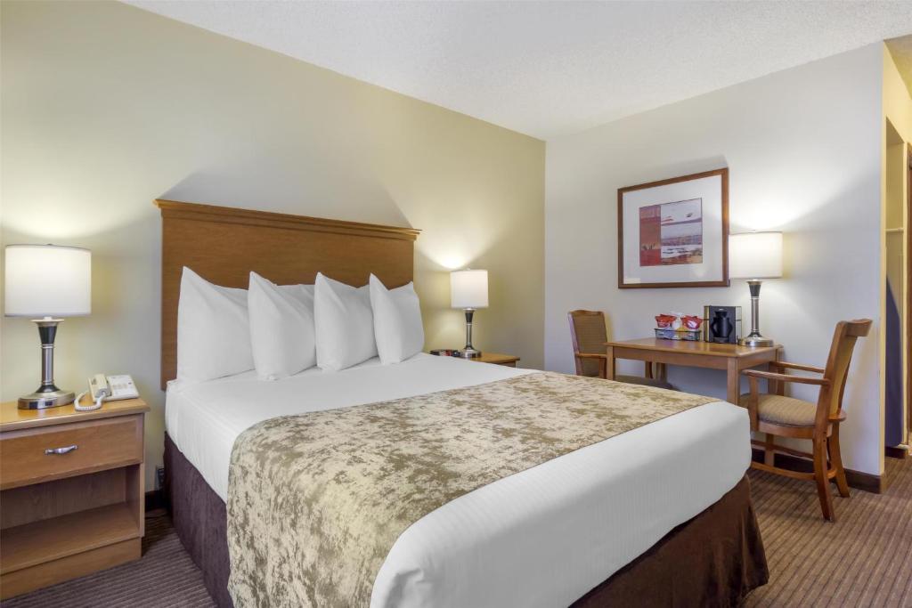 a hotel room with a large bed and a desk at Best Western Seattle Airport Hotel in SeaTac