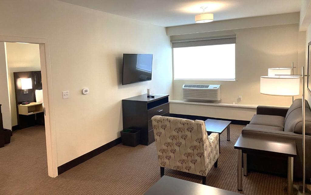 a living room with a couch and a television at Best Western Seattle Airport Hotel in SeaTac