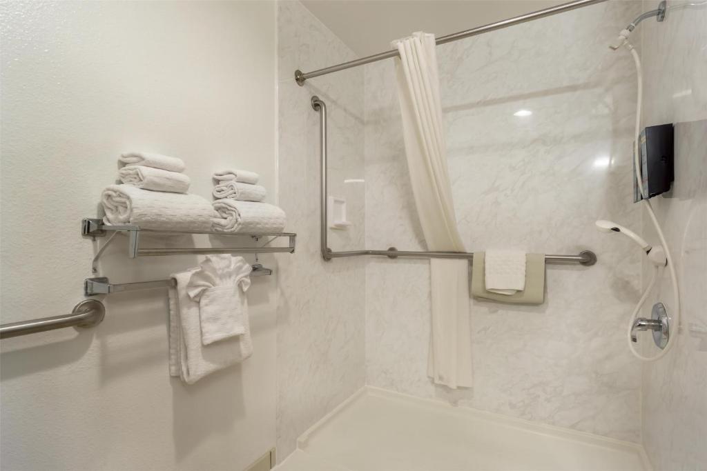 a bathroom with a shower and white towels at Best Western Seattle Airport Hotel in SeaTac