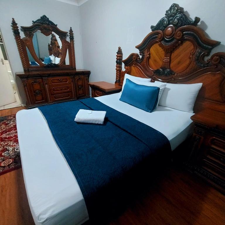 a bedroom with a large bed and a mirror at GALAXY BOSTON BELLVILLE in Cape Town
