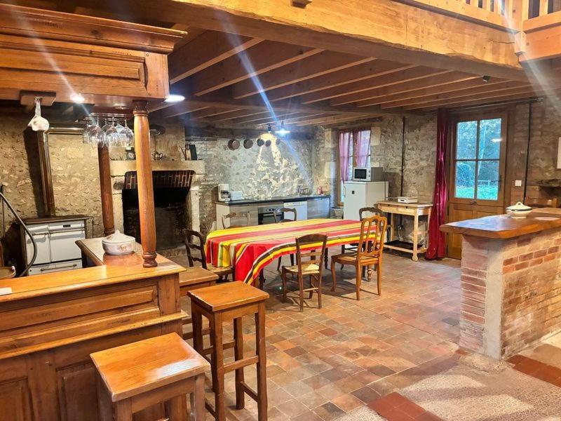 une cuisine avec une table et des chaises dans une pièce dans l'établissement Maison du garde forestier, à Cour-Cheverny