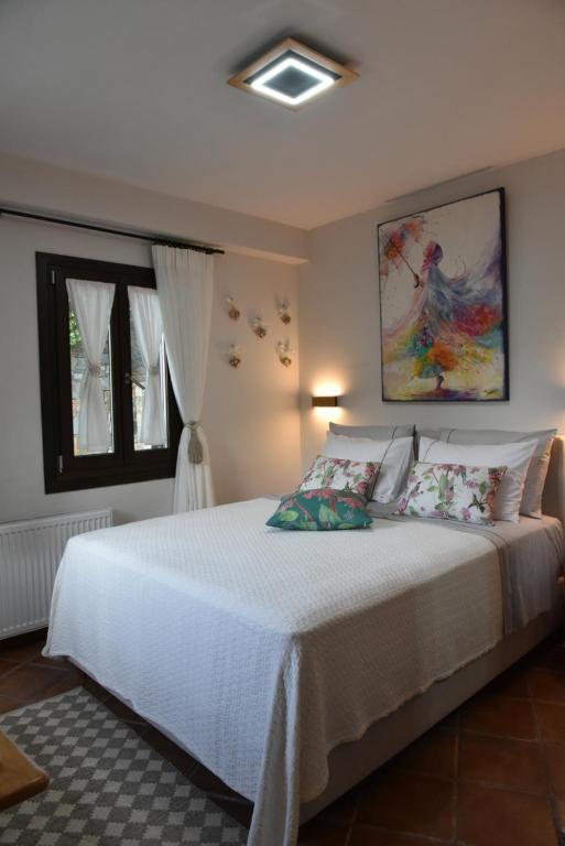 a bedroom with a white bed and a window at Ioni Home in Tsagarada