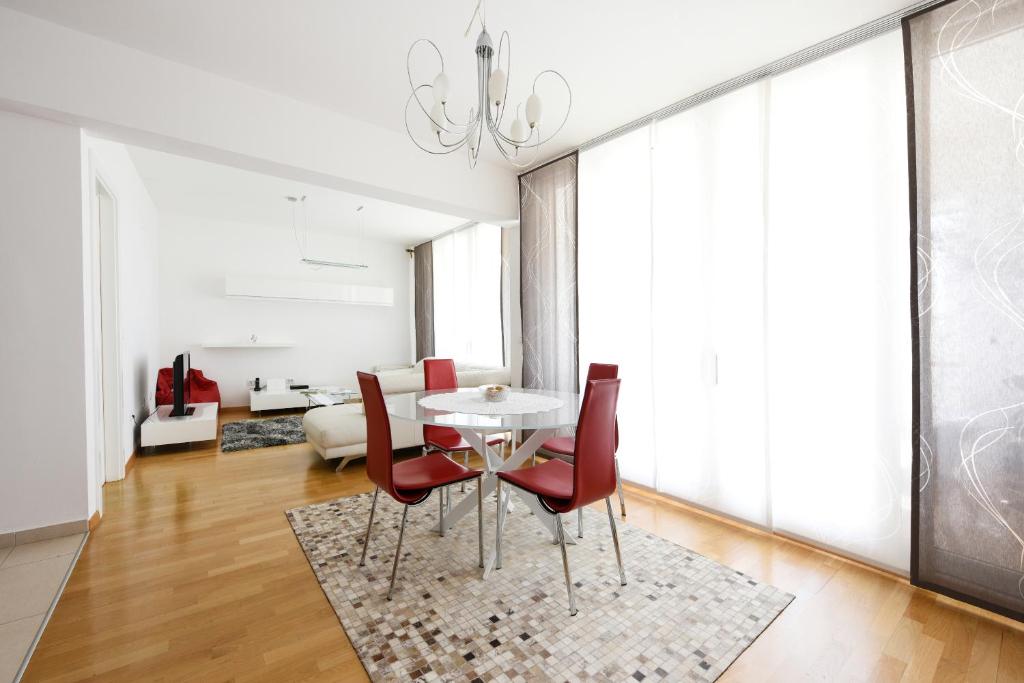 扎達爾的住宿－M&D apartment，一间带桌子和红色椅子的用餐室