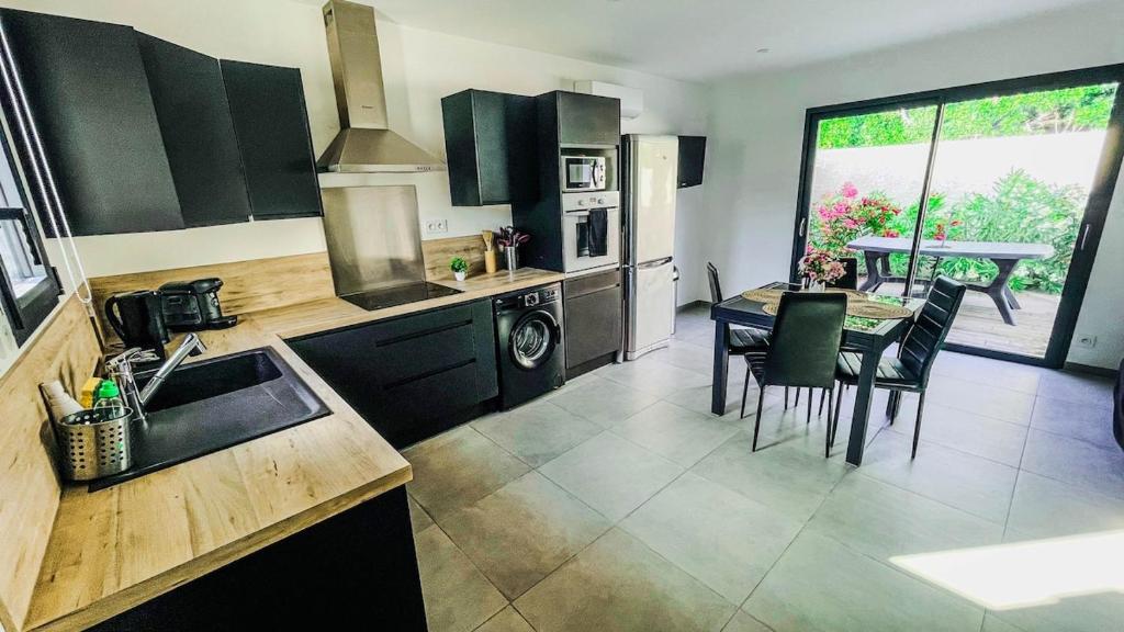 une cuisine avec une table et une salle à manger dans l'établissement Instant Janin - Logement T3 climatisé plain pied avec jardin, à Agde