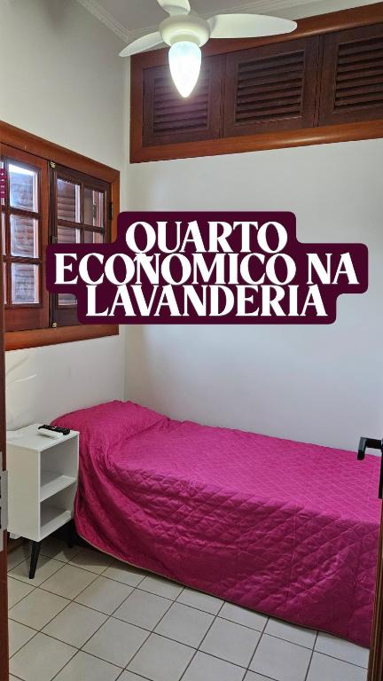 a bedroom with a bed with a sign on the wall at Casa Saito in Campinas