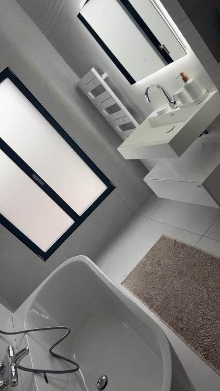 une salle de bain avec une baignoire blanche et un lavabo dans l'établissement Thechillhome, à Tigery