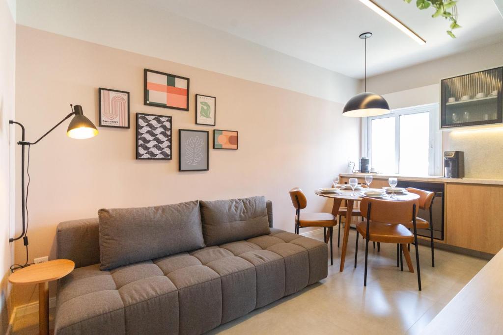 a living room with a couch and a table at Flat SP Suítes - Apartamentos por temporada in Sao Paulo