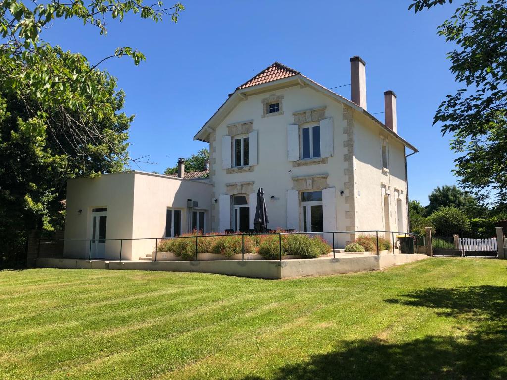 a large white house with a fence in front of a yard at Ancienne Poste de Montcaret in Montcaret