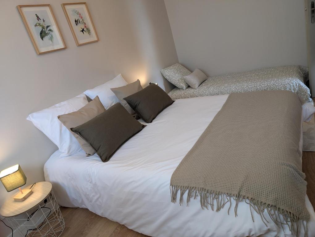 une chambre avec un grand lit blanc avec des oreillers dans l'établissement location calme et reposante à quelques minutes du zoo et proche des châteaux, à Noyers-sur-Cher