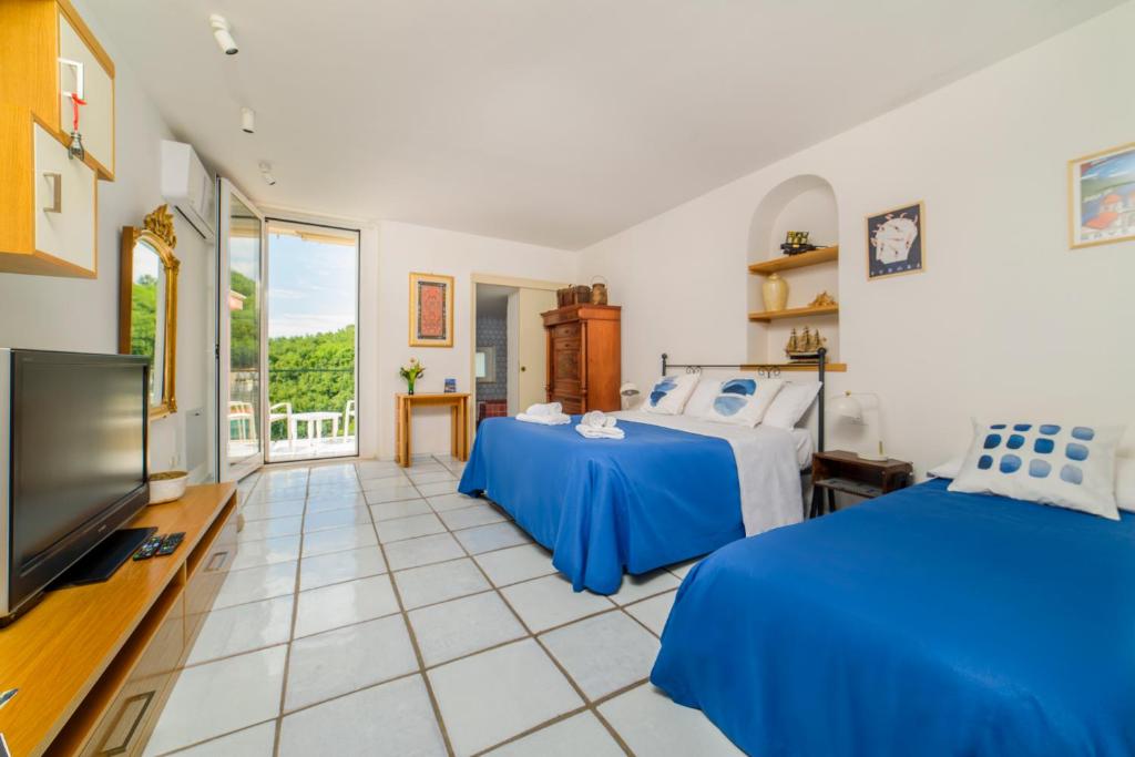 a bedroom with two beds and a flat screen tv at Casa di Zia Rosaria SEA VIEW in Vietri sul Mare