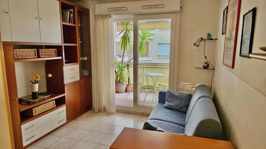 un salon avec un canapé et une porte coulissante en verre dans l'établissement Studio Nice proche gare Riquier et port, à Nice