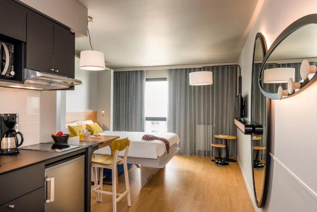 - une cuisine et un salon avec un lit dans une chambre dans l'établissement Aparthotel Adagio access Colombes La Défense, à Colombes