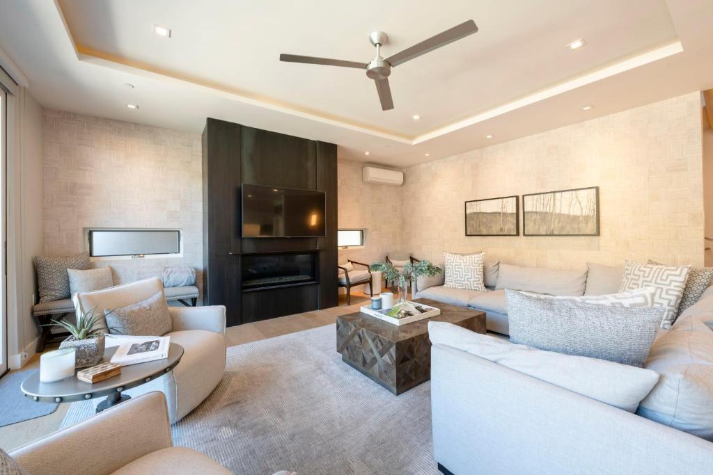 a living room with white furniture and a tv at Luxury Townhome with Spectacular Views. Private Hot Tub & Walking Distance to Main Street - in Park City