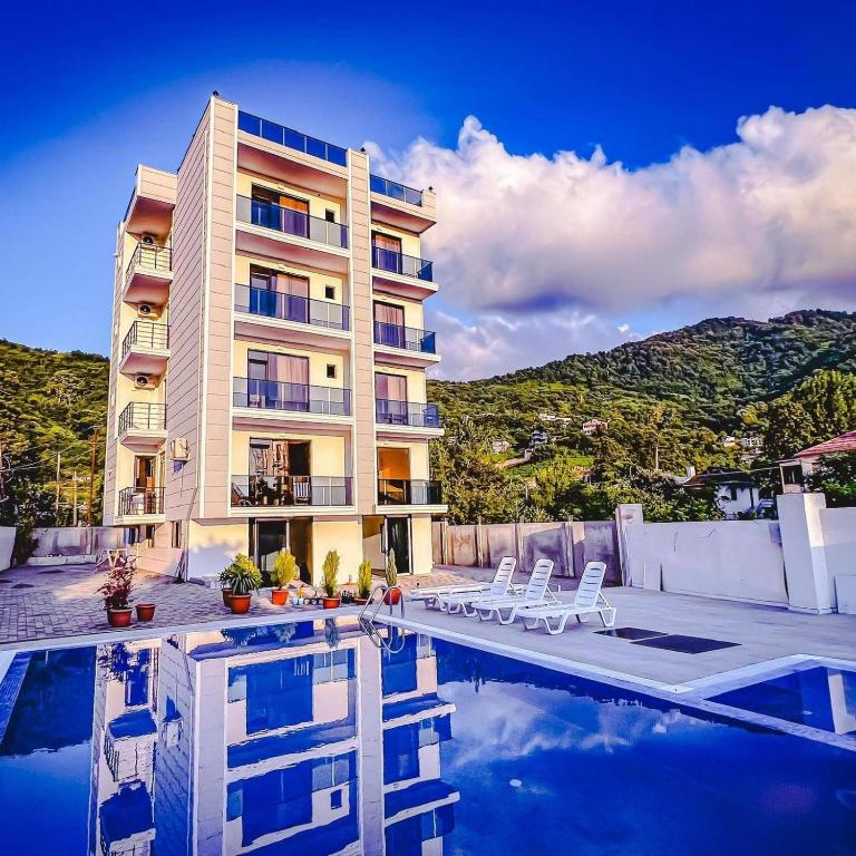a hotel with a swimming pool next to a building at Hotel Heart in Gonio