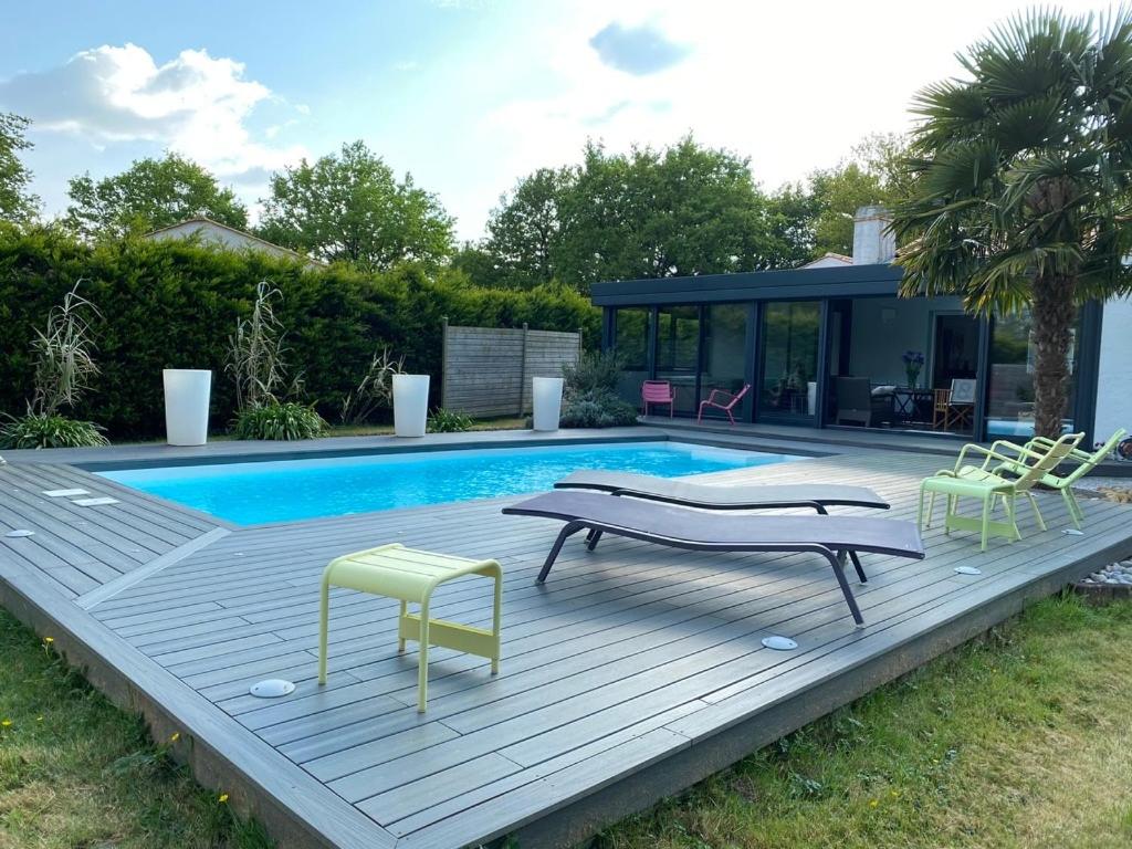 une piscine avec deux chaises et une maison dans l'établissement Villa d Exception avec piscine, à Sainte-Foy