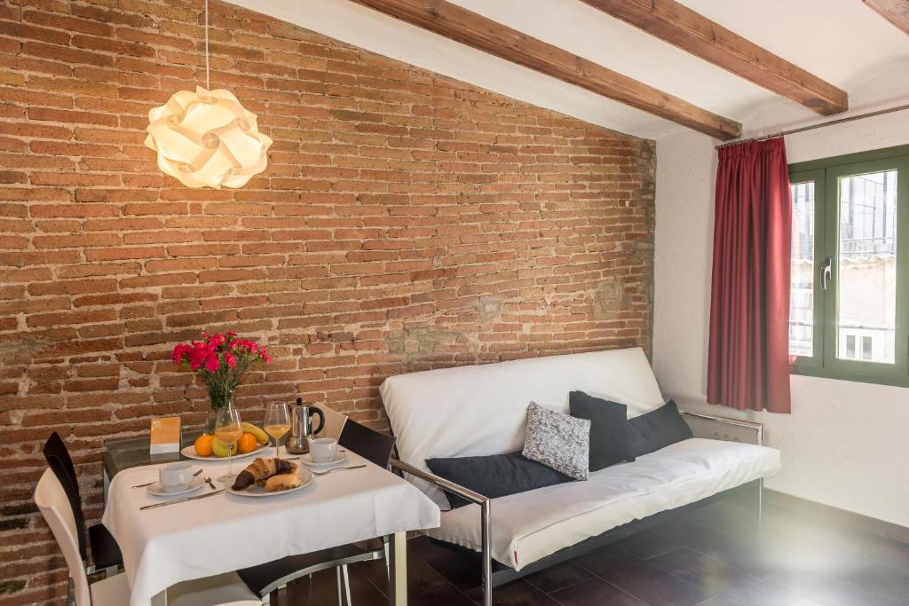 a living room with a couch and a brick wall at Apartaments Ciutat Vella in Barcelona