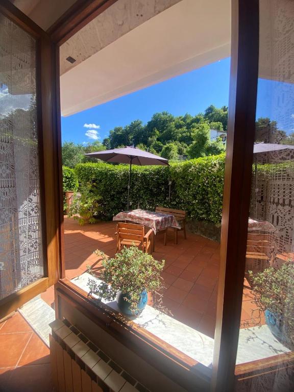 widok na patio ze stołem i parasolem w obiekcie Appartamento comodo per Lerici e 5 Terre w mieście Piano di Follo