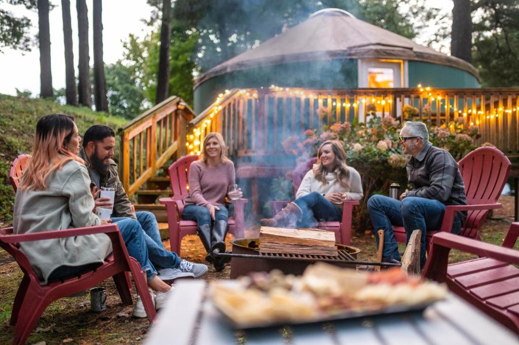 a group of people sitting around a fire pit at Circle M Camping Resort Yurt in Lancaster