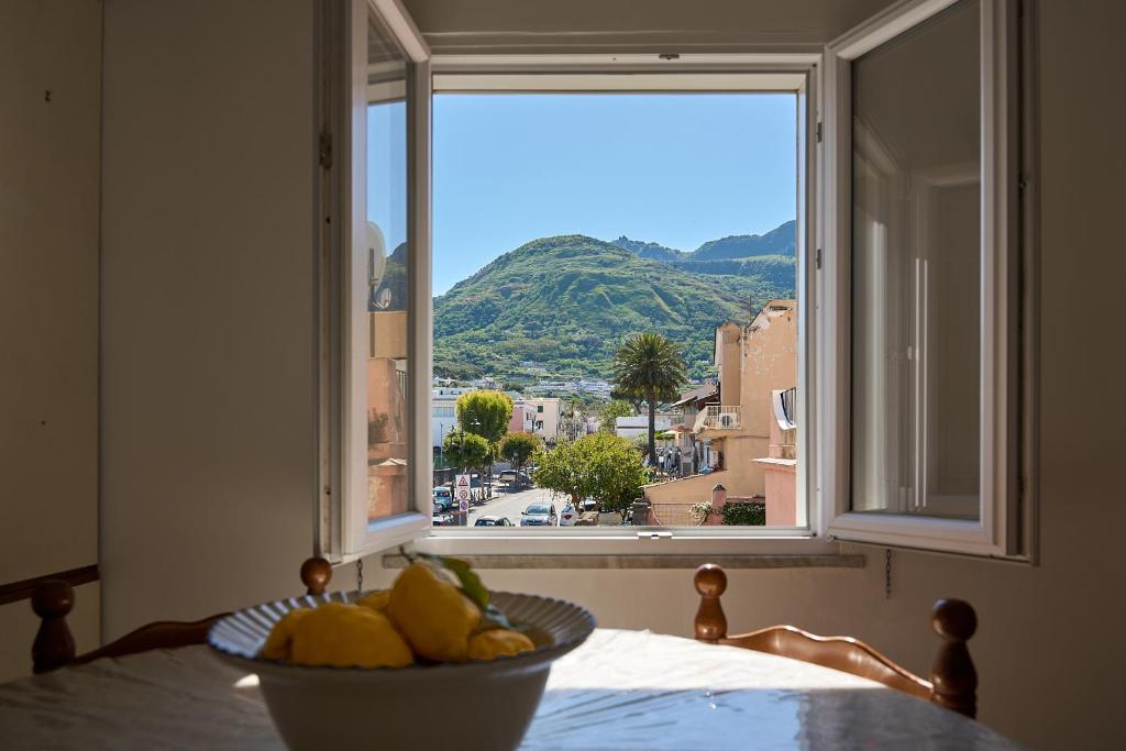 a bowl of fruit on a table in front of a window at Casa Olimpia in Forio d'Ischia