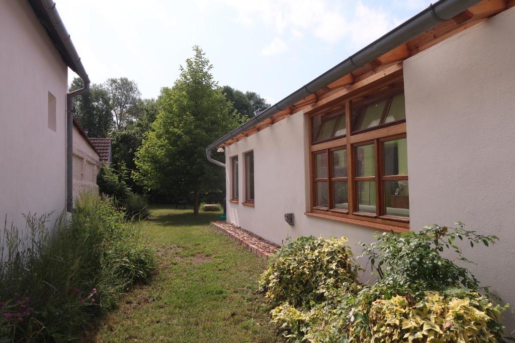 a white house with windows and a yard at Guest House Relax in Březí