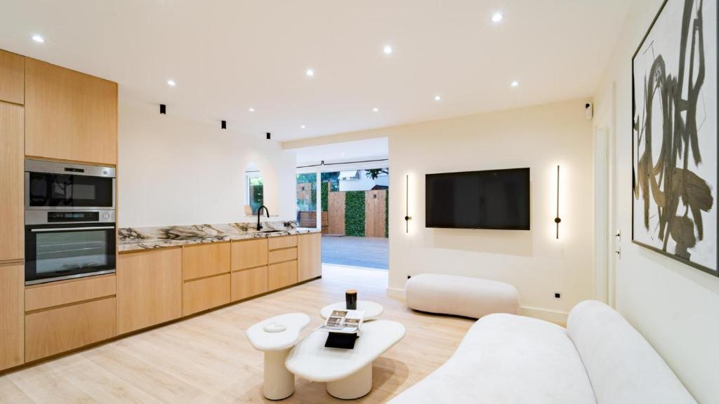 un salon avec un canapé blanc et une télévision dans l'établissement Cocoon in Cannes Martinez, à Cannes