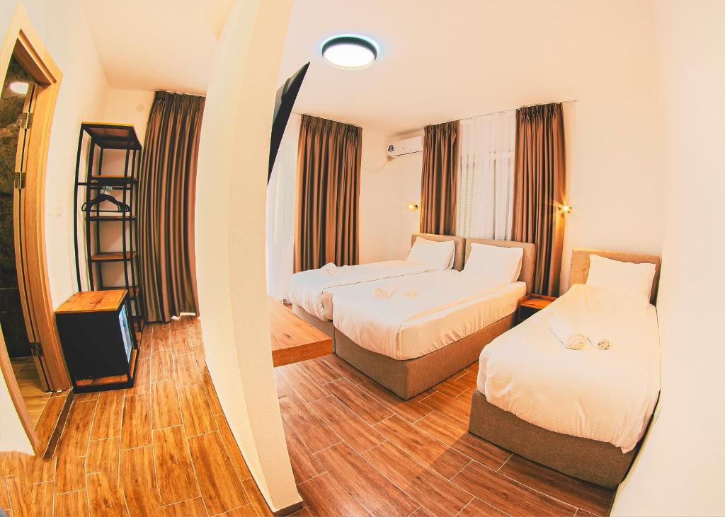 a hotel room with two beds and a television at MAKIS Luxury Apartments City Center Free Parking in Ohrid
