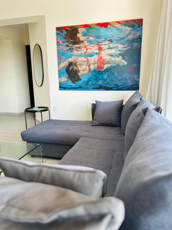 a living room with a couch and a painting at Serene Getaway Near Protaras in Paralimni