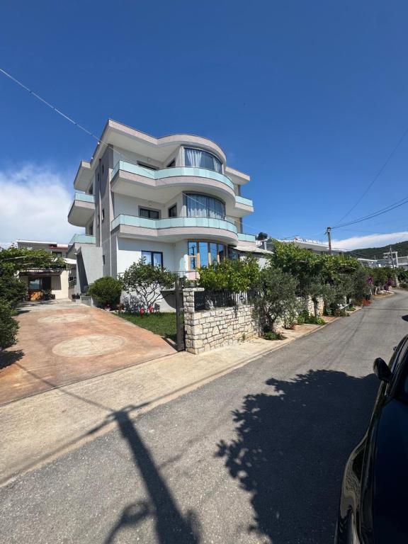 a large white building on the side of a street at Vila Olserd Shehu in Ksamil