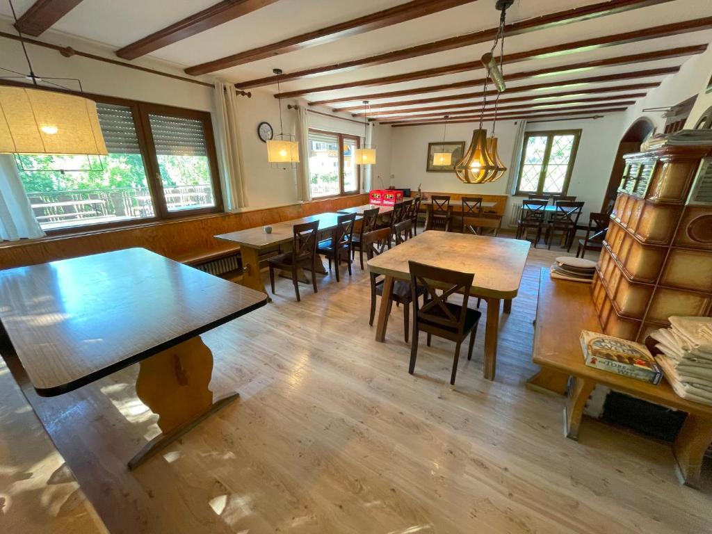 a dining room with tables and chairs and windows at Freizeitheim Wilhelm-Kiefer-Haus mit großem Grundstück, Feuerstelle, Tennisplatz in Bad Wildbad