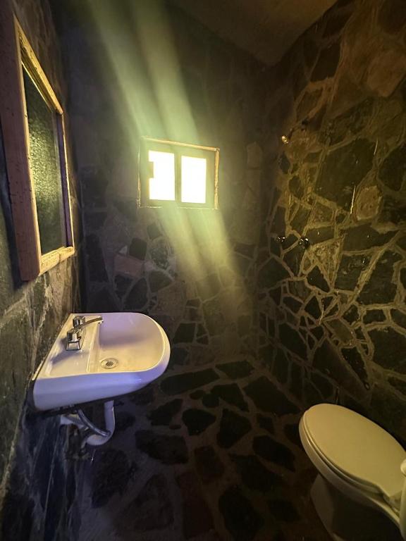 a bathroom with a sink and a window and a toilet at Román Cabañas del Mirador 4 in Pahuatlán del Valle