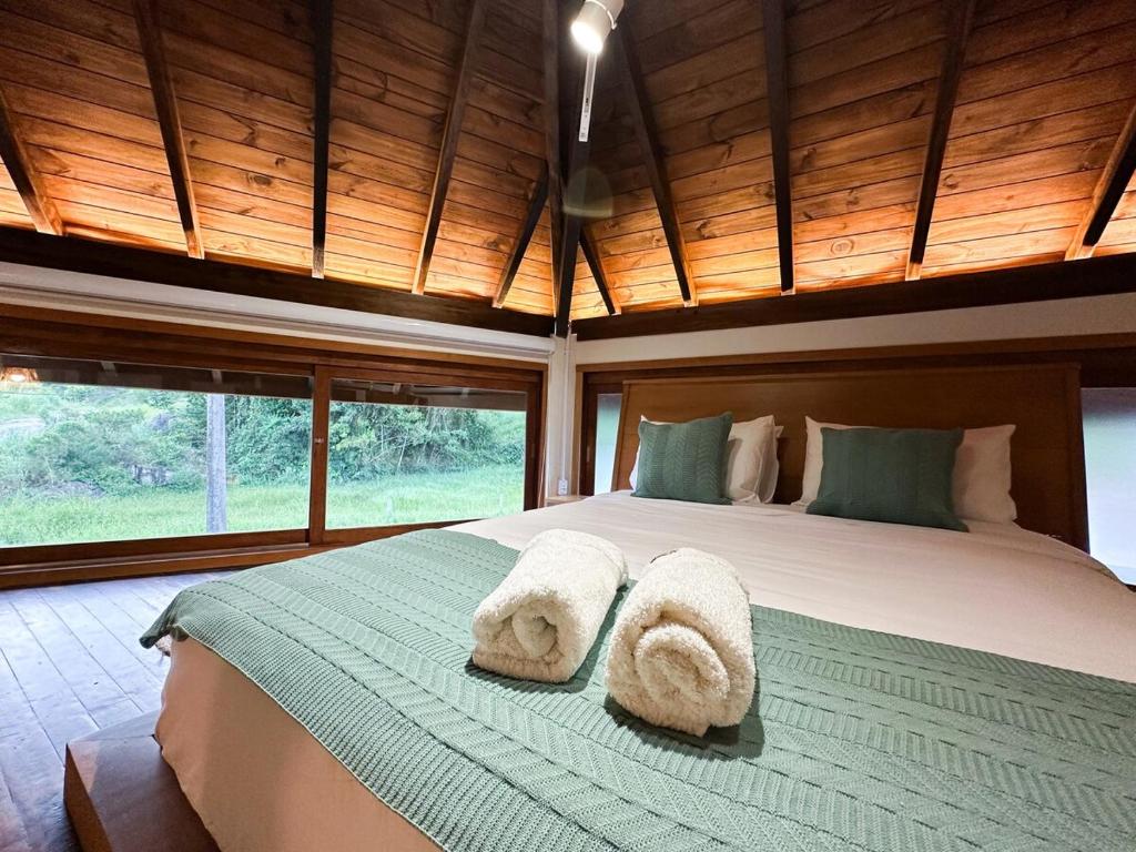 een slaapkamer met een groot bed met handdoeken erop bij Refúgio perto do mar em Mariscal 02 in Bombinhas