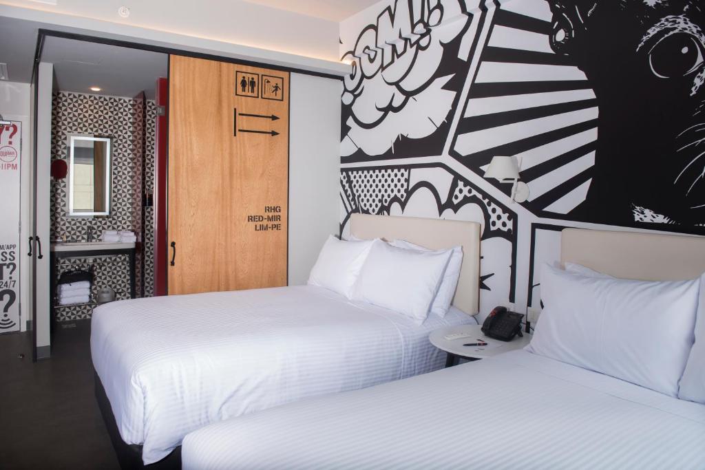 2 camas en una habitación de hotel con sábanas blancas en Radisson RED Miraflores, en Lima