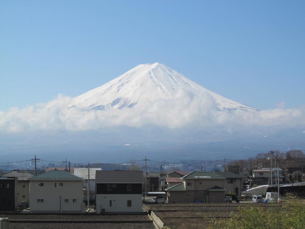 a snow covered mountain in the background of a city at Villa Orange Cabin in Fujikawaguchiko