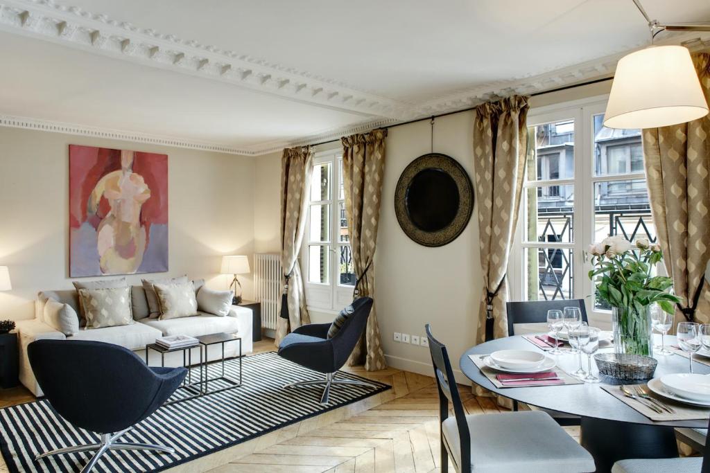 un salon avec un canapé et une table dans l'établissement Paris Louvre Elegant residence, à Paris