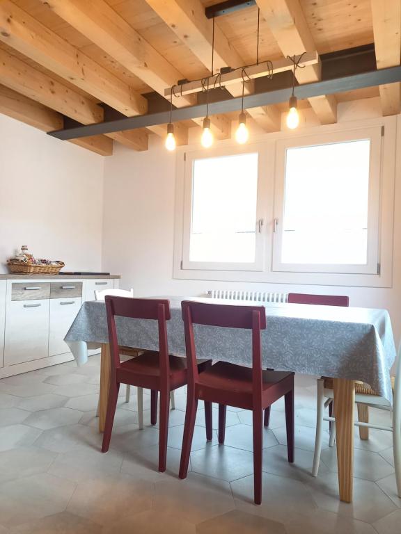 a dining room with a table and chairs and a kitchen at Luce del Mattino in San Vito al Tagliamento