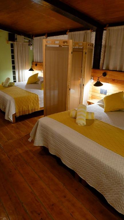 a bedroom with two beds with yellow sheets at Cabañas Chechén Chaká in Leona Vicario