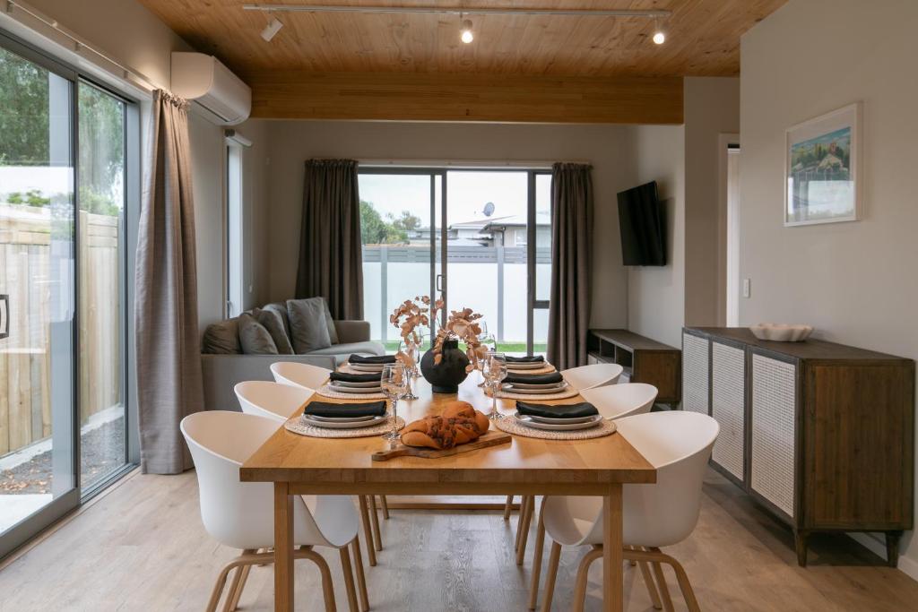 a dining room with a wooden table and chairs at Taradale Gem in Napier