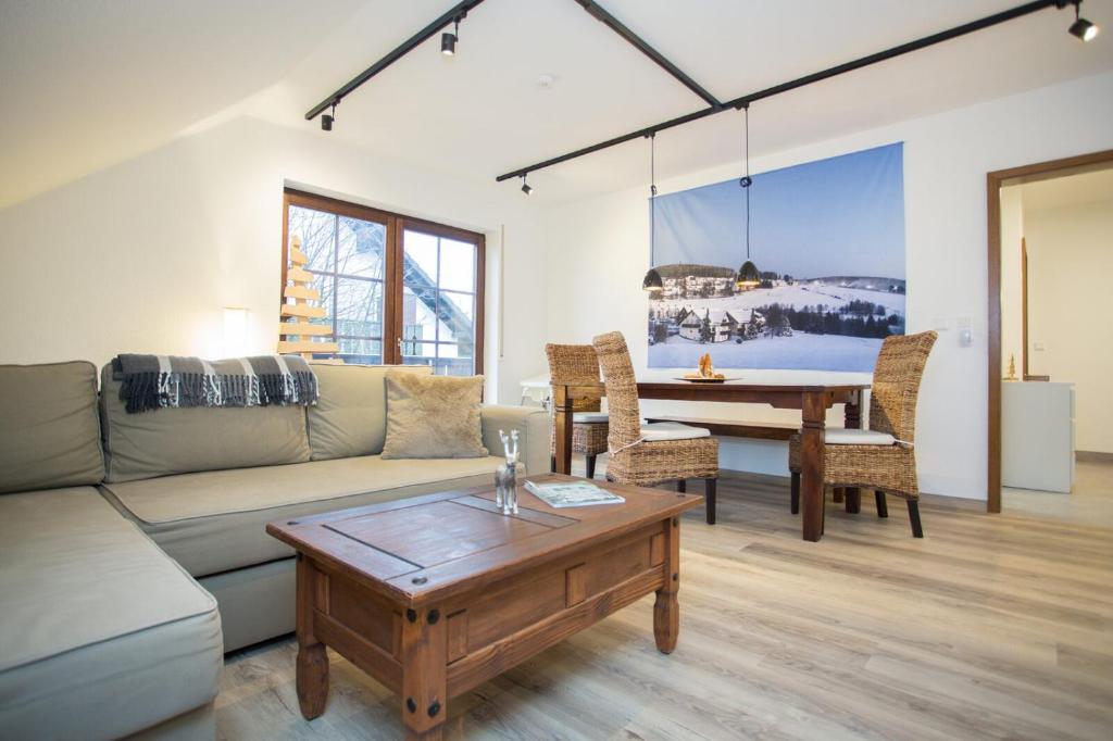 a living room with a couch and a table at Bear Apartment am Skihang in Winterberg