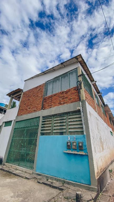 a brick building with a blue door on a street at Privê Coqueiral in São José da Coroa Grande