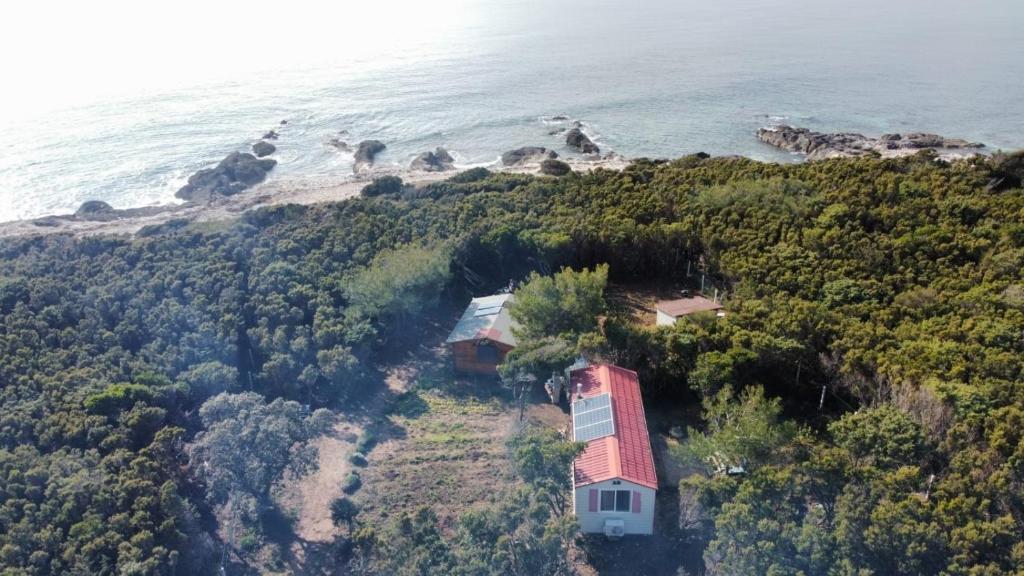 an aerial view of a house on a hill next to the ocean at Apartments by the sea Cove Kurila, Losinj - 24571 in Mali Lošinj