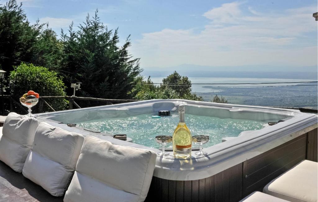 a hot tub with a bottle of wine sitting on a patio at Villa Al Tramonto in Lisciano Niccone