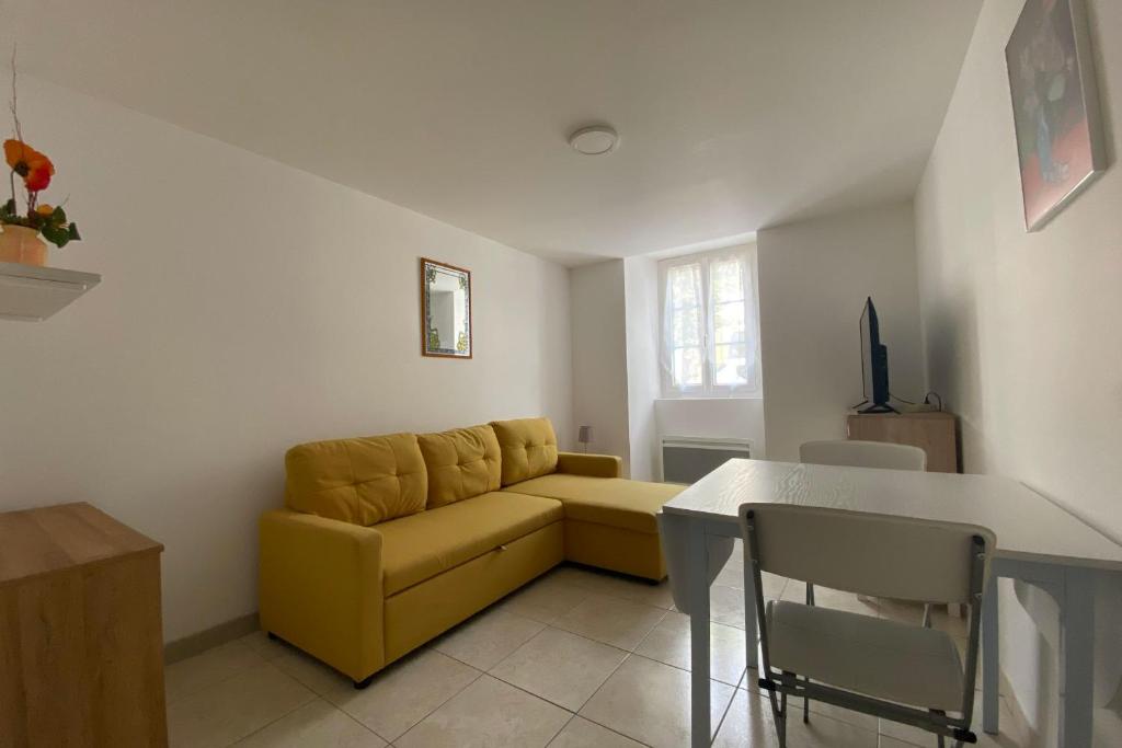un salon avec un canapé jaune et une table dans l'établissement The Little Cambo, à Cambo-les-Bains